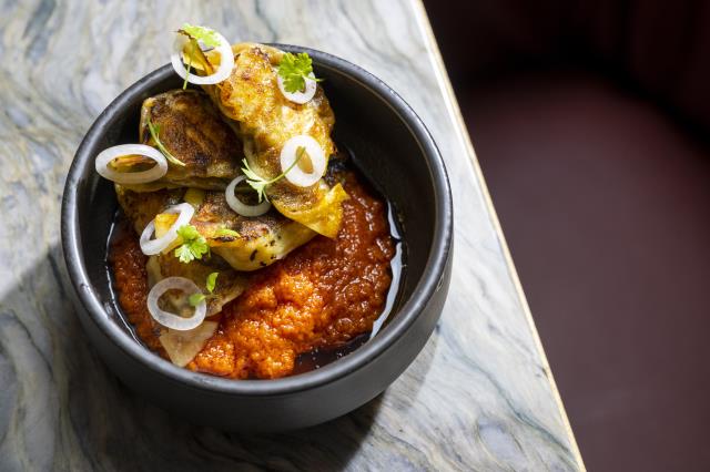 Les Dumplings Egusi farcis au crabe noir et accompagnés de ragoût rouge nigérian et de pickles. d'oignons.