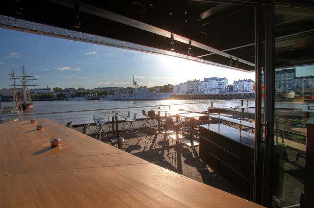 Le bar du O Deck, à Nantes, s'organise autour d'un long comptoir en bois, qui file jusque sur l'un des ponts du complexe flottant.