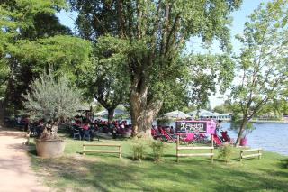 La terrasse se déploie au bord de la rivière, l'équipe cultive l'esprit de vacances