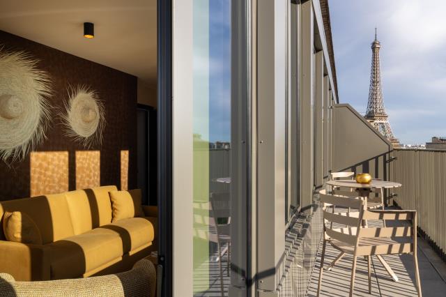 Une chambre de la Maison Hamelin, avec balcon et vue sur la tour Eiffel. 