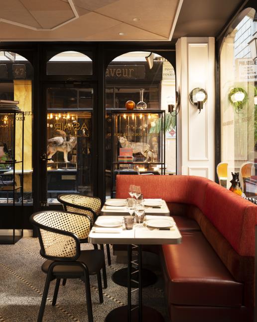 Retour à l'esprit brasserie avec banquettes rouges, chaises cannées et mosaïque au sol.