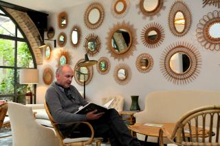 François Dumas dans un salon de lecture où la décoration est faite de miroirs.