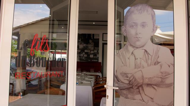 Hervé Mie à 7 ans la photo sur les portes symbolise la transmission qui fait le succès le l'enseigne Le Fils du Boucher