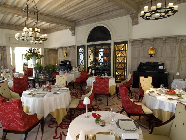 Poutres apparentes, lustres en fils de métal, tapis tissé d'entrelacs  l'immense salle à manger en impose, oeuvre d'Alberto Pinto dans le cadre d'une profonde rénovation du Relais et Châteaux 5 étoiles en 2007.