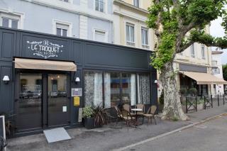 Un platane sépare symboliquement l'ancien pub, à gauche, du Riche hôtel, à droite.