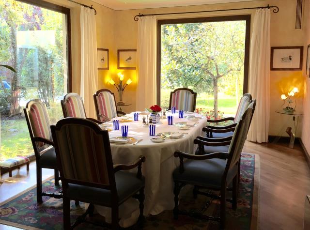 Une table confinée dans la salle de restaurant, avec vue sur le jardin.