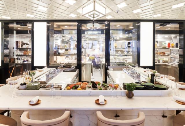 Le Sea Bar, comptoir de marbre avec vue sur les cuisiniers préparant chaque plat minute autour des produits de la mer.