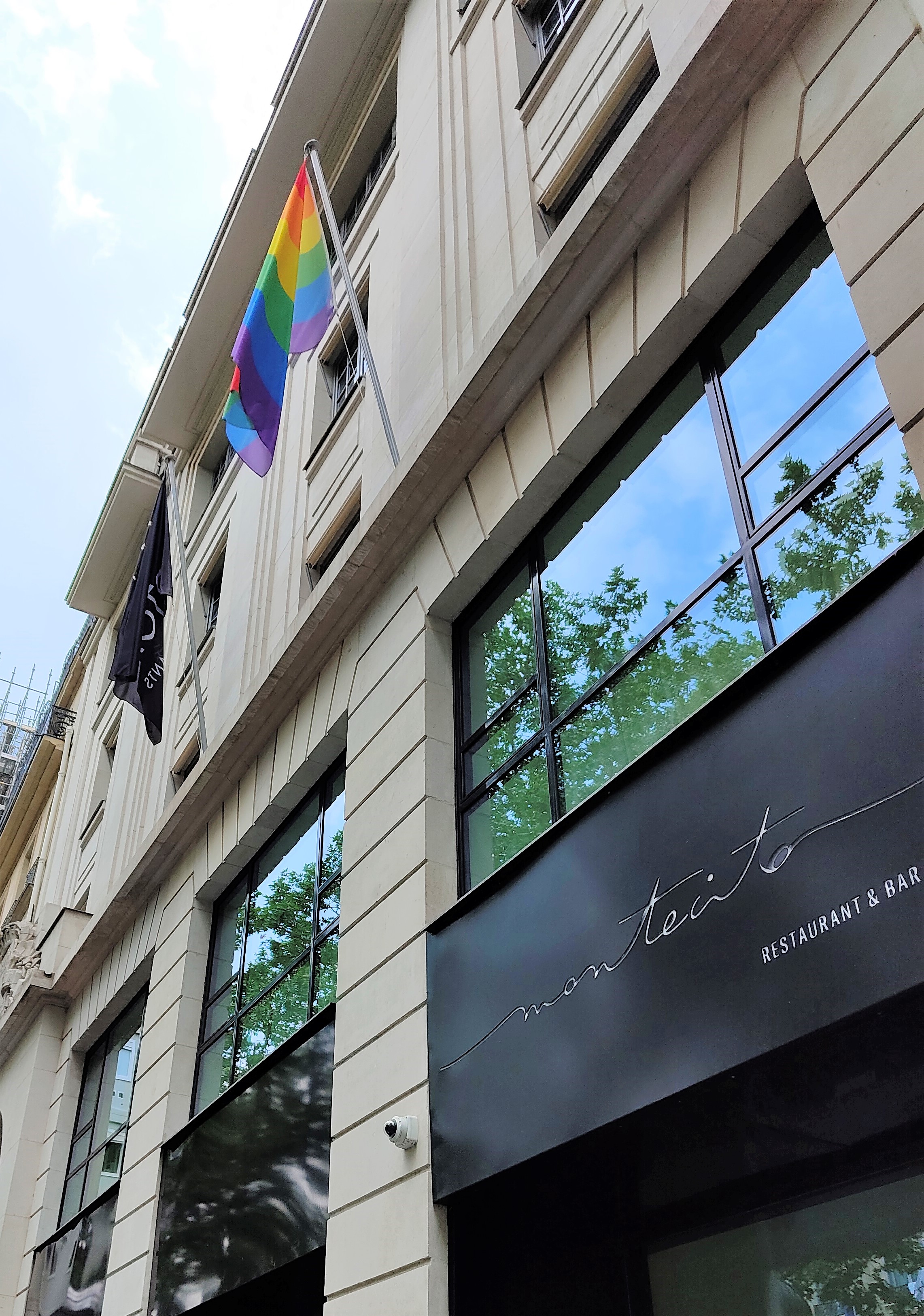 Le drapeau LGBTQIA+ flotte en façade du Kimpton St Honoré pendant tout le mois de juin.